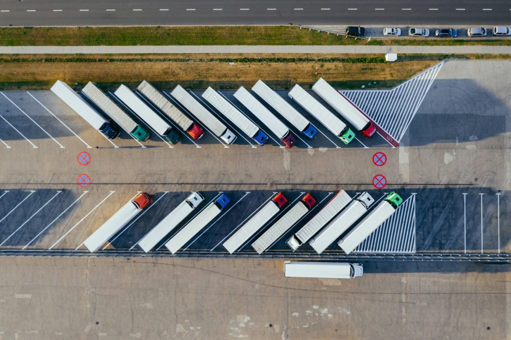 Camions de marchandises alignés sur le parking d’un dépôt logistique