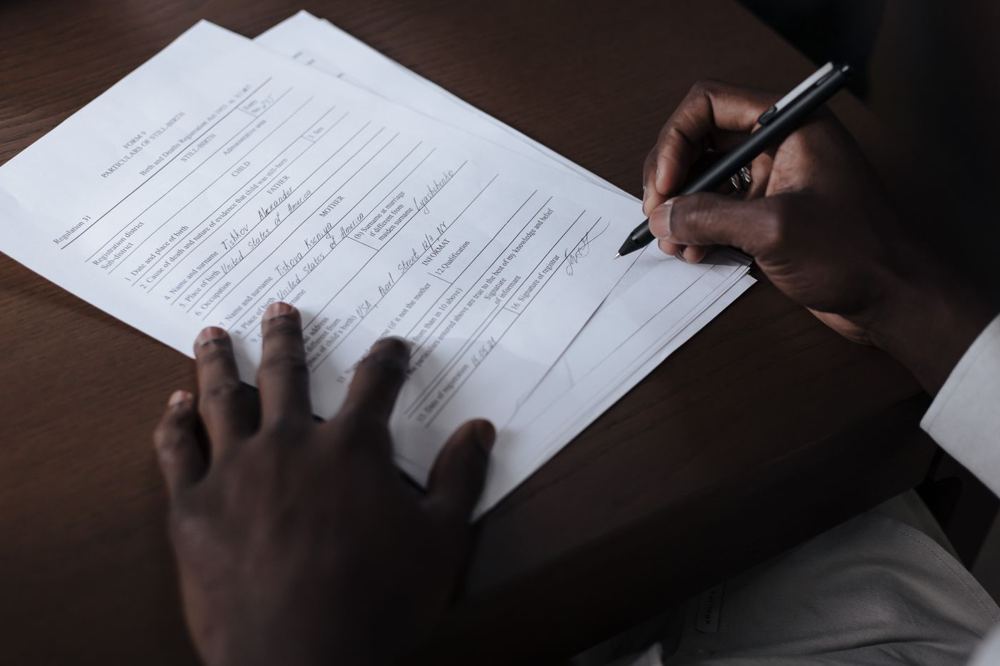 Homme signant un document officiel avec un stylo à table
