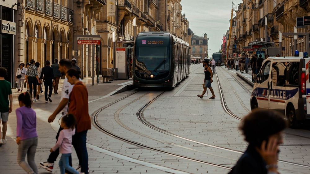Rue animée de Bordeaux avec tramway et piétons