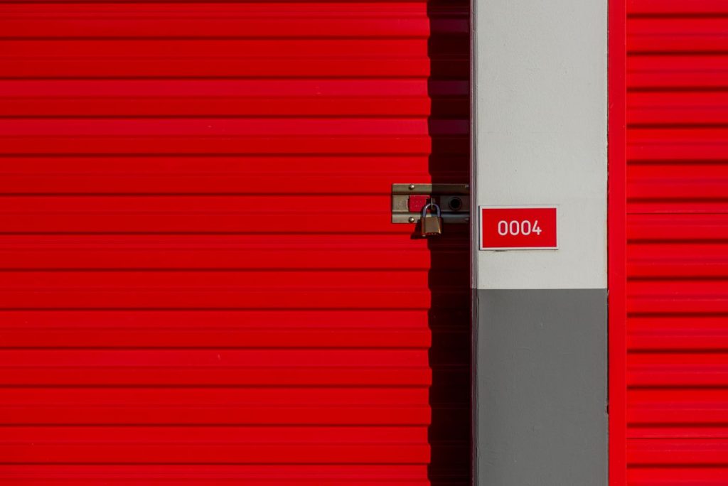 Porte numérotée d’un box de stockage fermée par un cadenas