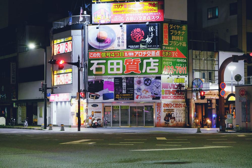 Enseignes lumineuses en caisson dans une rue commerçante de nuit
