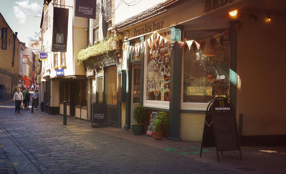 Rue piétonne pavée avec commerces et architecture historique