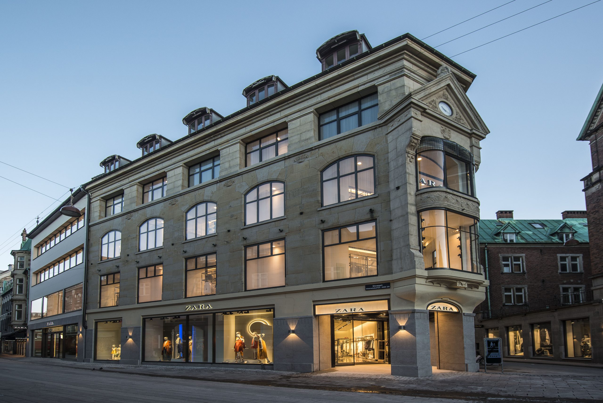 Façade en pierre d'un immeuble ancien à Copenhague avec plusieurs enseignes Zara en lettres capitales
