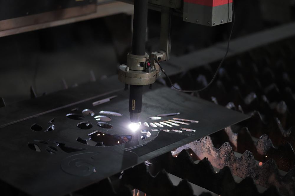 Machine de découpe plasma travaillant une plaque métallique en atelier