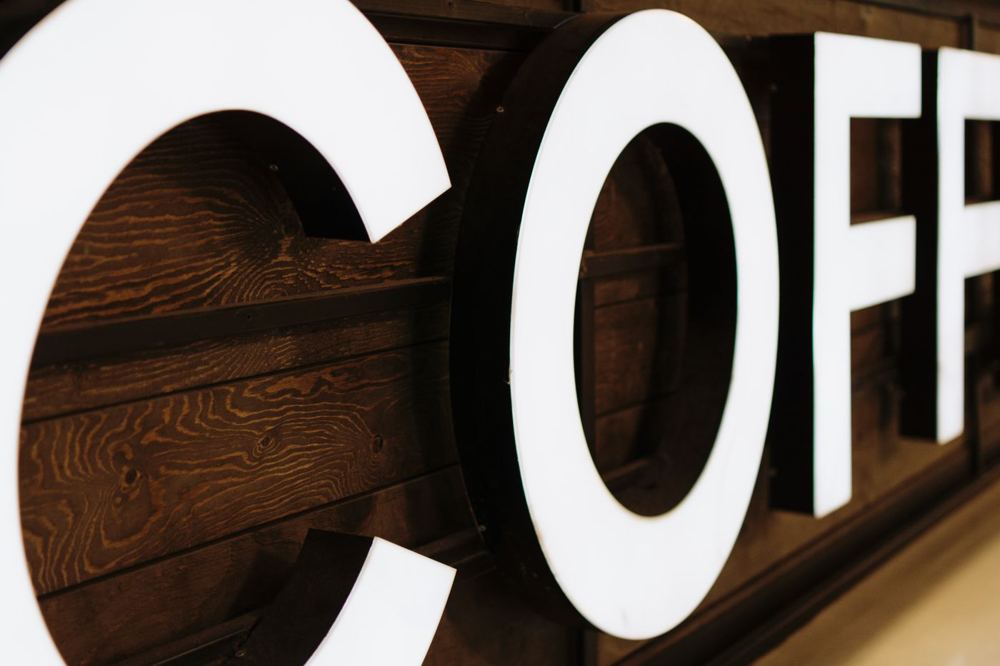 Grande enseigne de café illuminée avec fond en bois