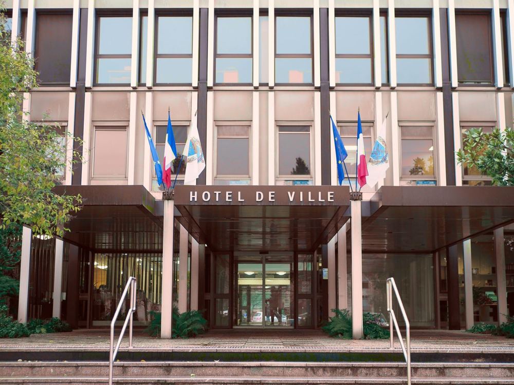 Façade de mairie française avec drapeaux et architecture moderne