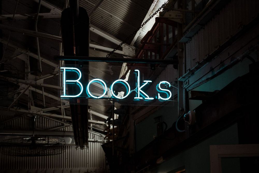 Enseigne néon lumineuse Books dans une librairie tamisée