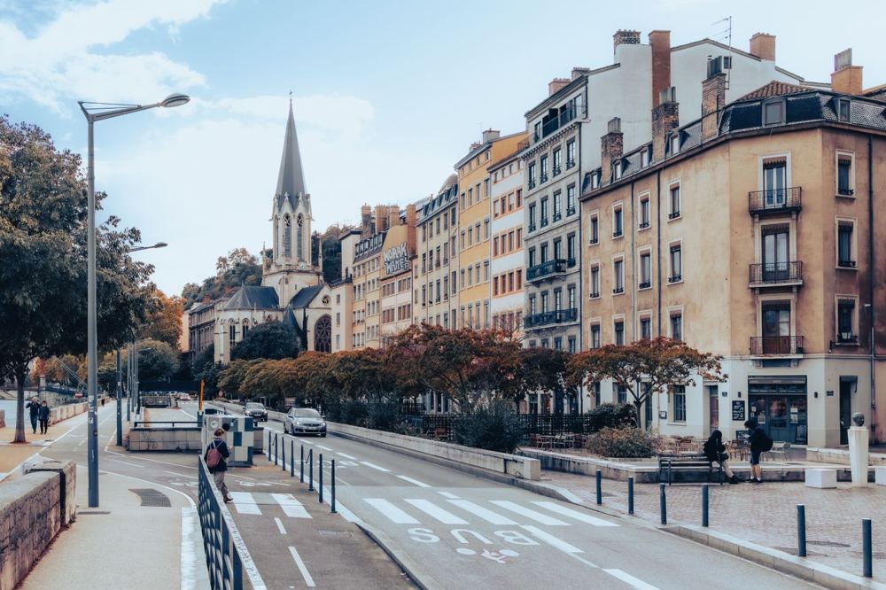 Scène de rue à Lyon avec architecture historique et vie urbaine