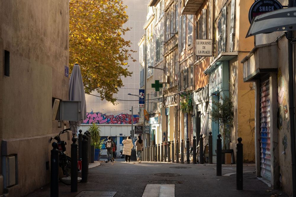 Rue animée de Marseille avec passants et lumière chaude