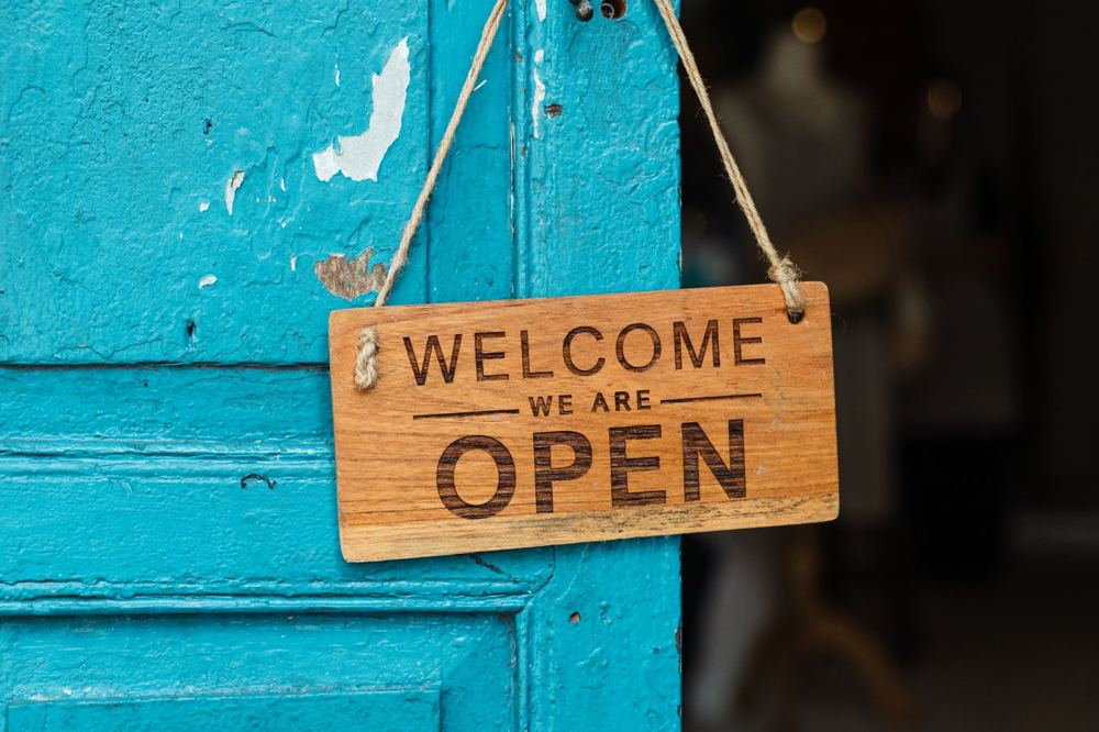 Enseigne artisanale en bois sur une porte bleue