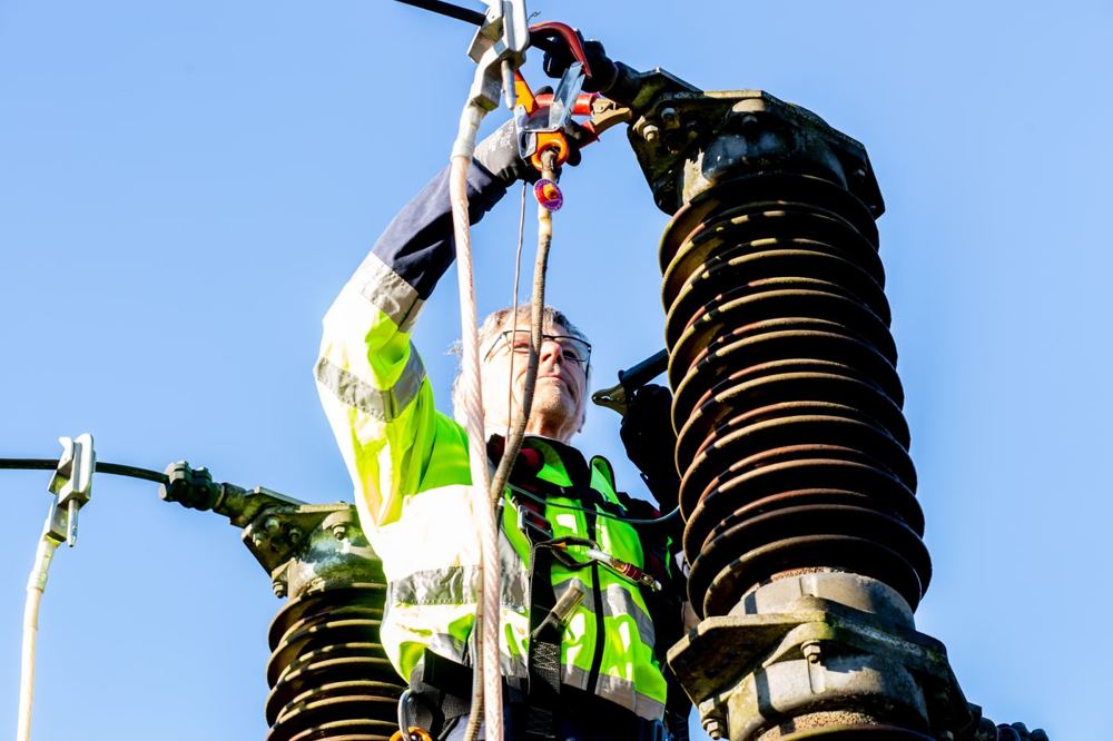 Technicien en équipement de sécurité inspectant une installation haute tension