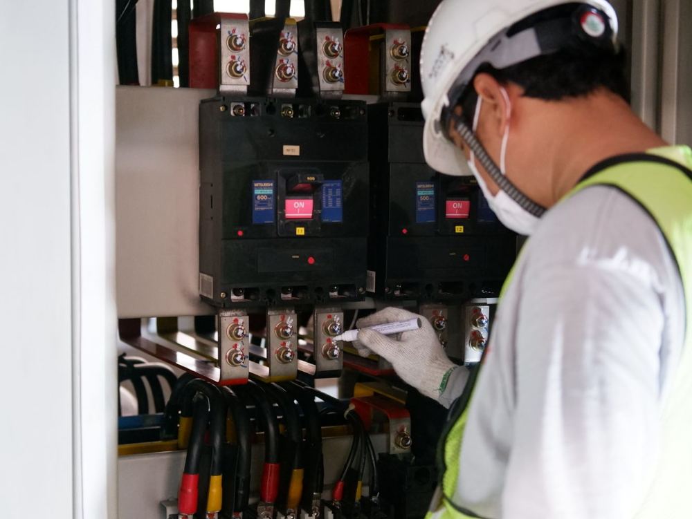 Technicien en équipement de sécurité inspectant des tableaux électriques