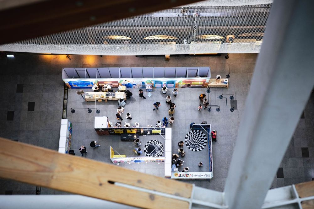 Vue en hauteur d’un espace d’exposition indoor avec allées et stands