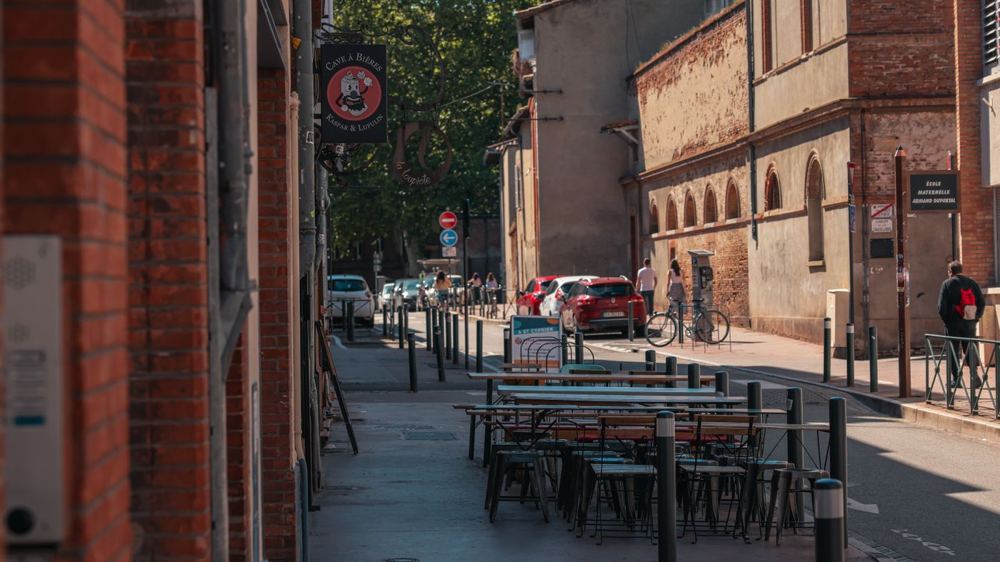 Rue commerçante avec terrasses et architecture en brique à Toulouse