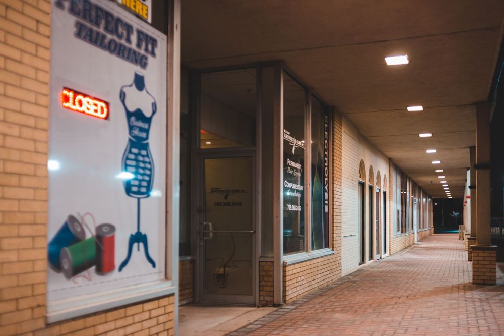 Façades de boutiques avec plusieurs enseignes visibles la nuit