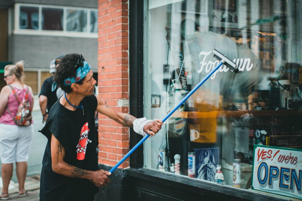 Nettoyage d’une vitrine de magasin à la raclette avant intervention