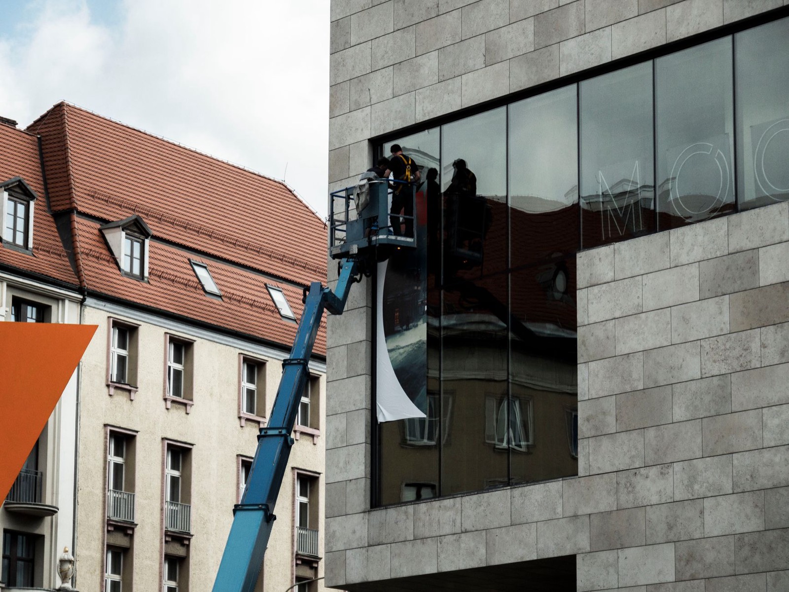 Installation d'une grande bâche publicitaire imprimée sur une façade de commerce