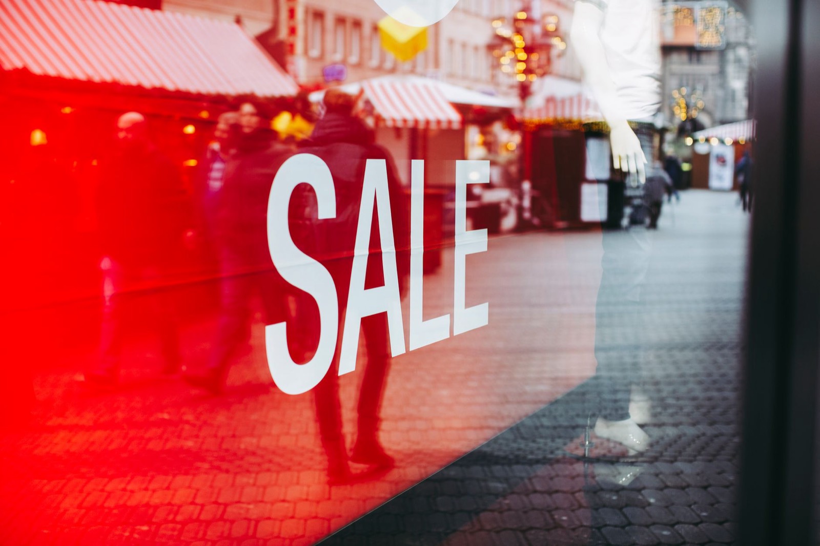 passant qui lève les yeux vers l'enseigne lumineuse d'une vitrine de commerce