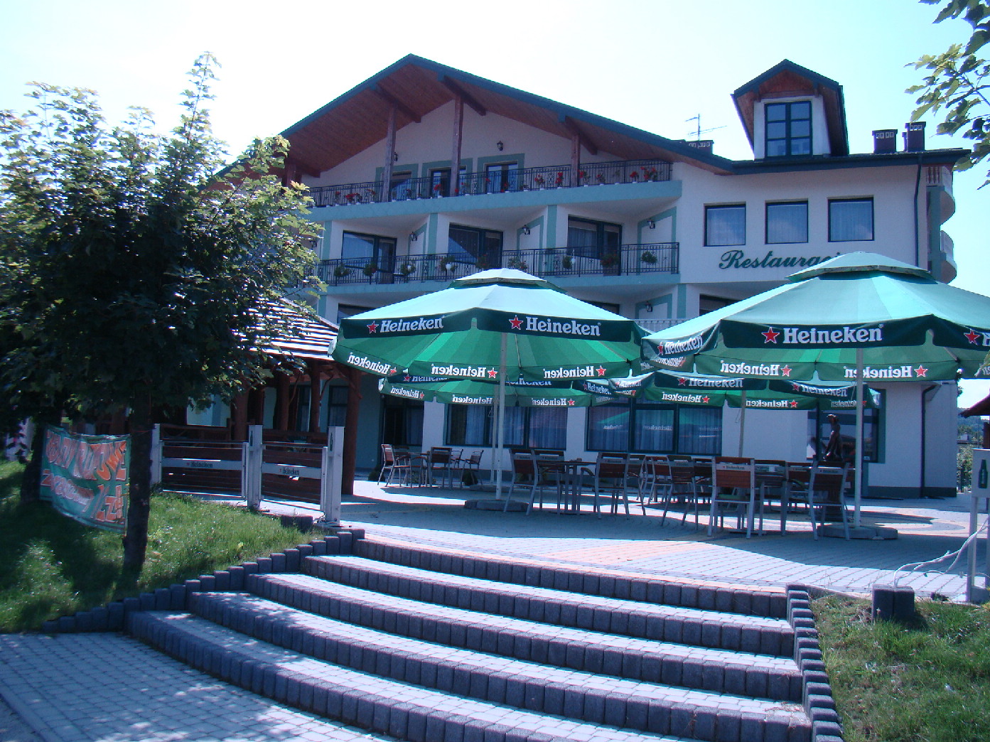 Terrasse d'un bar-restaurant avec parasols siglés Heineken devant la façade