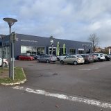 Façade d une concession Peugeot à Beaune, avec logo et signalétique de marque