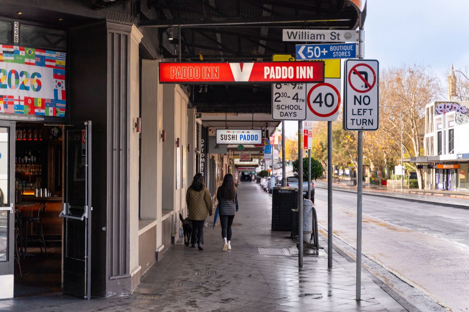 Enseigne et vitrine de commerce vues depuis la rue, éclairage du soir